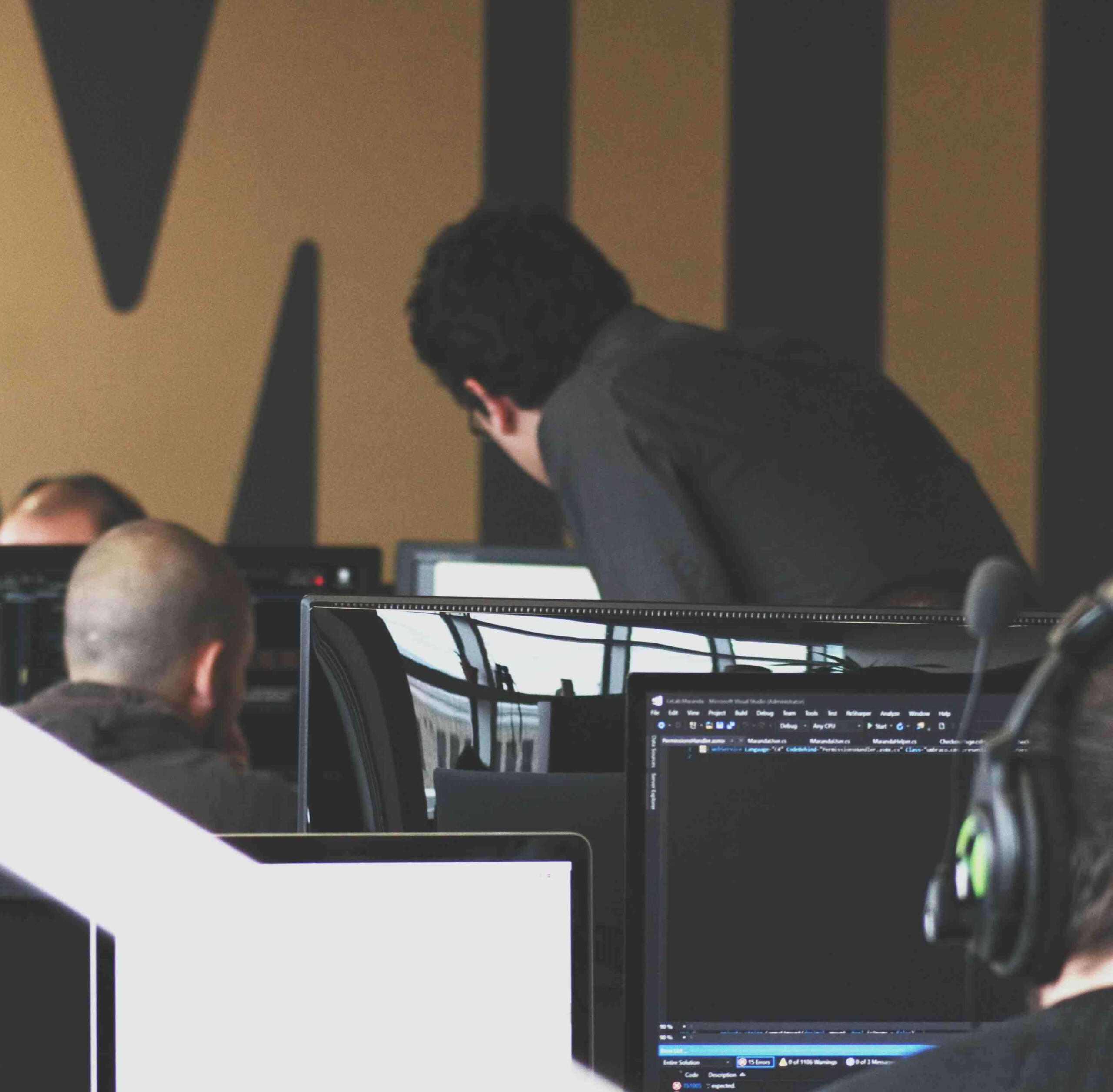 Two people reviewing a document on a desktop computer.